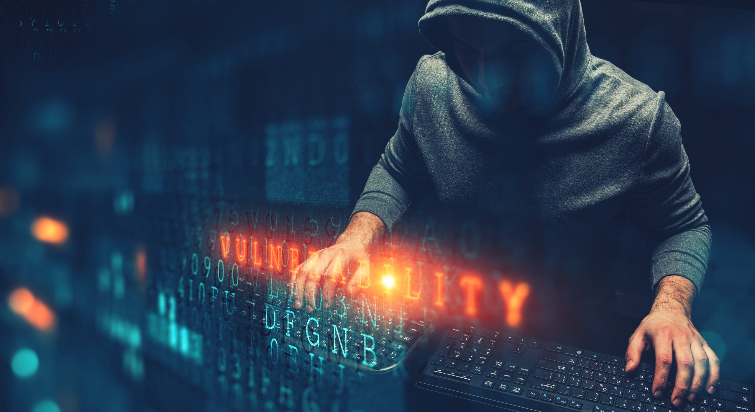 Hacker with his hands on two keypads and digital computer code