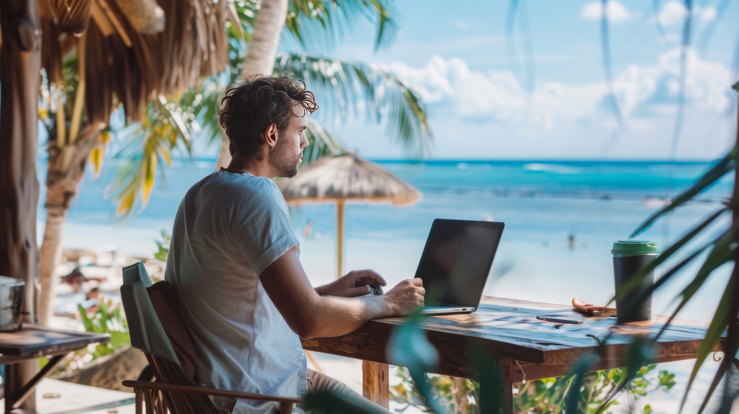 A young professional man working remotely from beach highlighting the freedom and flexibility of modern work arrangements.